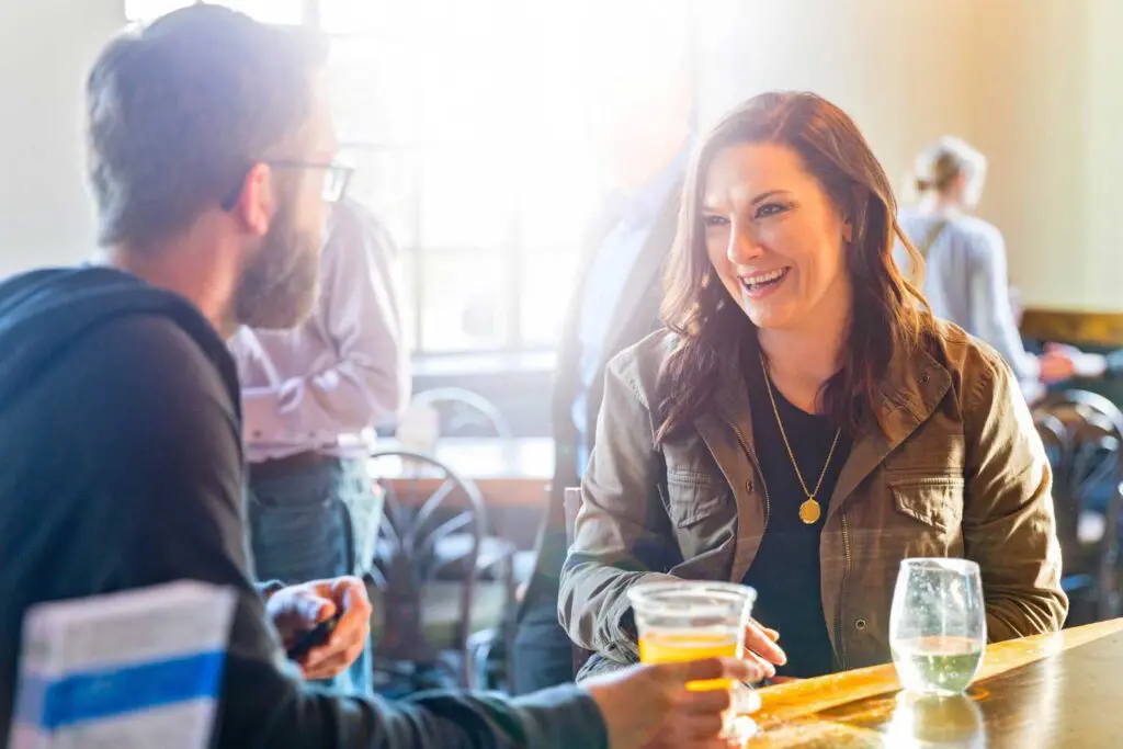 People having a conversation at bar of Dock & Paddle over drinks